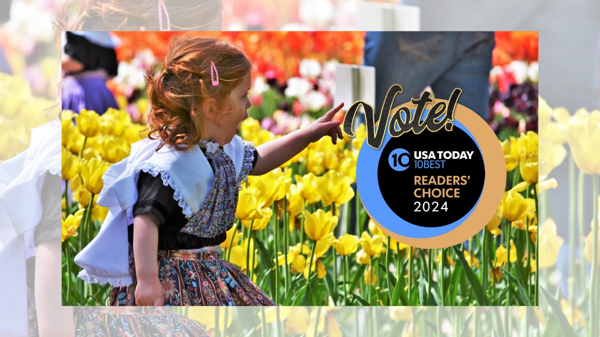 A little red-haired girl in a traditional Dutch costume sits in a field of tulips pointing to the USA Today's 10Best Reader's Choice Awards Logo